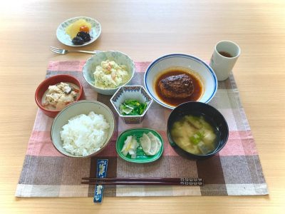 煮込みハンバーグポテトサラダ菜の花と貝柱の酢味噌和え卯の花香の物みそ汁デザート　りんごのコンポート、金柑、プルーン ぶどうの木 デイサービス from Instagram