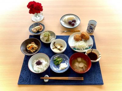 コロッケ　キャベツぜんまいやキノコの煮物オイルサーディン”だし"のせ冷奴いちじくのゴマソース香の物みそ汁デザートぶどう、梨🍐 ぶどうの木 デイサービス from Instagram