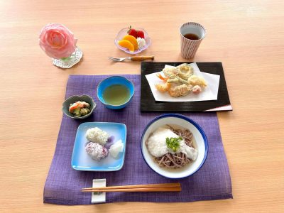 天ぷら(海老、茗荷、かぼちゃ、筍、 いんげん、ゴーヤ、トマト)とろろそば青菜と紫蘇のおにぎりきゅうりの酢の物香の物デザートいちご、黄桃クリーム添え ぶどうの木 デイサービス from Instagram